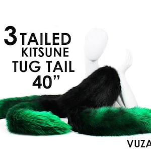 Może przedstawiać: Trójogonowy ogon kitsune, zwany "kitsune tug tail", o długości 40 cali, z czarnym i zielonym futrem. Ogon jest przymocowany do manekina.