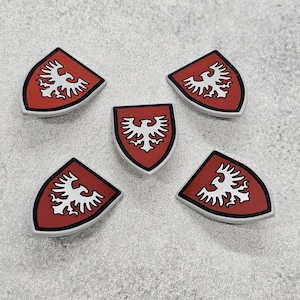 May include: Five white shields with a red background and a white eagle design. The shields are made of plastic and are approximately 2 inches in diameter.