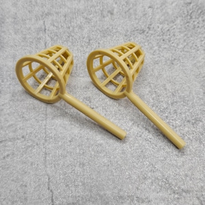 May include: Two beige plastic scoops with a mesh design. The scoops have long handles.