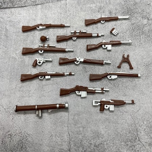 May include: A collection of 12 brown toy guns, including rifles, pistols, and a bazooka. The guns are made of plastic and have silver accents.