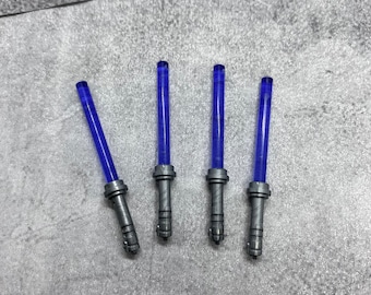 May include: Four blue lightsaber toys with silver handles. The lightsabers are arranged in a row on a gray surface.
