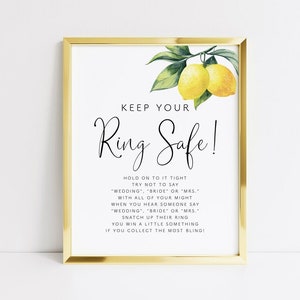 May include: A printable sign with a lemon illustration and the text "Keep Your Ring Safe!"  Hold on to it tight, try not to say "wedding", "bride" or "mrs." with all of your might. When you hear someone say "wedding", "bride" or "mrs." snatch up their ring. You win a little something if you collect the most bling!
