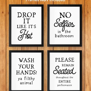 May include: Four black framed prints with white backgrounds and black text. The prints read "Drop it like it's hot", "No selfies in the bathroom", "Wash your hands! Ya filthy animal", and "Please remain seated throughout the entire performance".