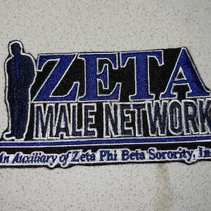 Może przedstawiać: Prostokątna naszywka z napisem "ZETA MALE NETWORK" w niebieskie i białe litery na czarnym tle. Naszywka zawiera sylwetkę osoby po lewej stronie oraz napis "An Auxiliary of Zeta Phi Beta Sorority, Inc." na dole.