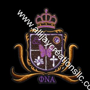 Może przedstawiać: Haftowana naszywka z motywem tarczy, korony, motyla, krzyża i kwiatu lotosu. Naszywka jest w odcieniach brązu, fioletu i złota, z napisem "ΦNA" na dole. Widoczny jest również adres strony internetowej "www.allijaycreationsllc.co".