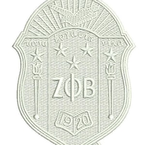 May include: Embroidered crest in off-white, featuring a shield shape with an eagle at the top. The crest includes stars, torches, and the letters ZΦB, with the year 1920. The design has a textured, stitched appearance.
