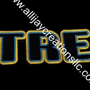 May include: Embroidered patch with the word "TRE" in black, outlined in gold and blue. The patch is on a black background. The website address "www.allijaycreationsllc.com" is printed diagonally across the image.