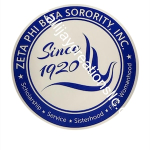 Könnte beinhalten: Ein runder Aufkleber mit weißem Hintergrund und blauem Rand. Der Text "ZETA PHI BETA SORORITY, INC." befindet sich in einem blauen Bogen oben. In der Mitte stehen die Worte "Since 1920" und ein stilisiertes Design.