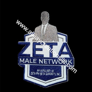 Może przedstawiać: Haftowana naszywka z napisem "ZETA MALE NETWORK" w kolorze niebieskim i białym oraz sylwetką osoby w garniturze. Naszywka jest pomocnicza dla Zeta Phi Beta Sorority, Inc. Widoczny jest również adres strony internetowej www.allijayocreationslle.com.