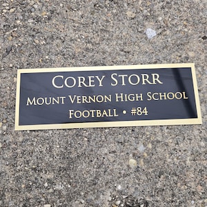 May include: A white ceramic mug with a black handle and the text "But First, Coffee" in a black, bold font. The mug is sitting on a white surface. The mug is approximately 4 inches tall.