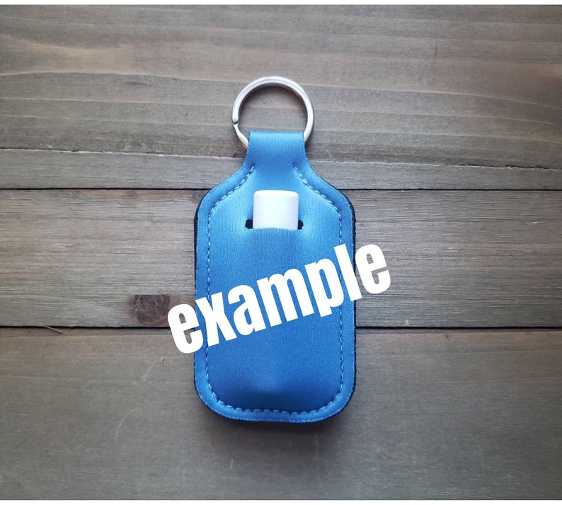 Pu&ograve; includere: Portachiavi in tessuto blu con un porta-tubo bianco e la parola "esempio" stampata sul davanti.