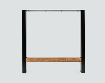 May include: Black metal table legs with a wood top shelf. The legs are rectangular and the shelf is a simple, flat piece of wood.