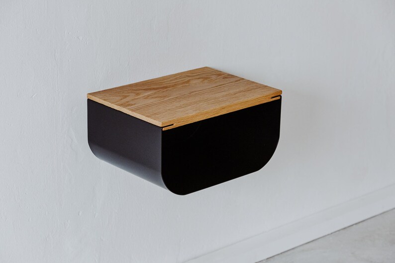 May include: A black wall-mounted nightstand with a curved front and a wood top.