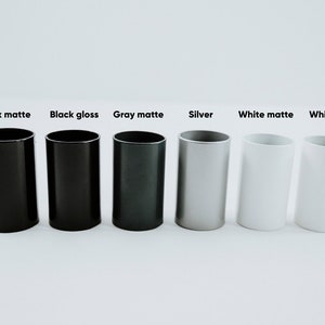 May include: Six cylindrical containers in different finishes: black matte, black gloss, gray matte, silver, white matte, and white gloss.