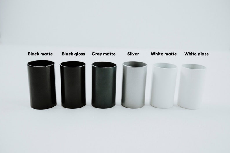 May include: Six cylindrical containers in different finishes: black matte, black gloss, gray matte, silver, white matte, and white gloss.