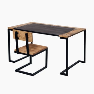 May include: A black metal desk with a wooden top and a matching wooden chair. The desk has a simple, modern design with a rectangular top and a single, straight leg on each side. The chair has a simple, rectangular seat and back.