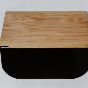 May include: A wooden shelf with a black metal base. The shelf has a curved front edge and a natural wood finish.