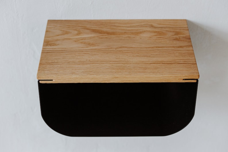 May include: A wooden shelf with a black metal base. The shelf has a curved front edge and a natural wood finish.