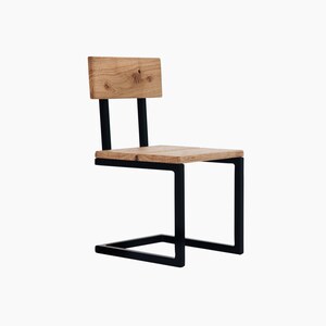 May include: A black metal chair with a wooden seat and backrest. The chair has a unique design with a curved metal frame.