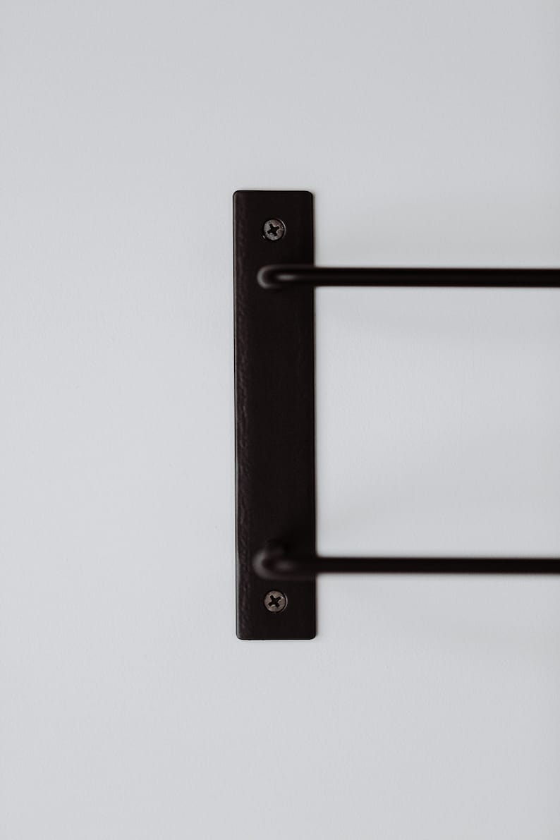 Pode incluir: Toalheiro de parede de metal preto com duas barras. O toalheiro &eacute; fixado &agrave; parede com dois parafusos.