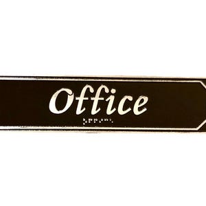 May include: Black rectangular sign with rounded corners and white trim. The sign says "Office" in white cursive lettering.