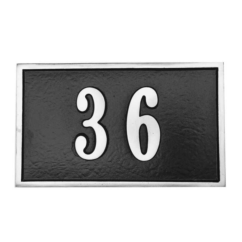 May include: Black rectangular house number plaque with a silver border and white raised numbers "36".