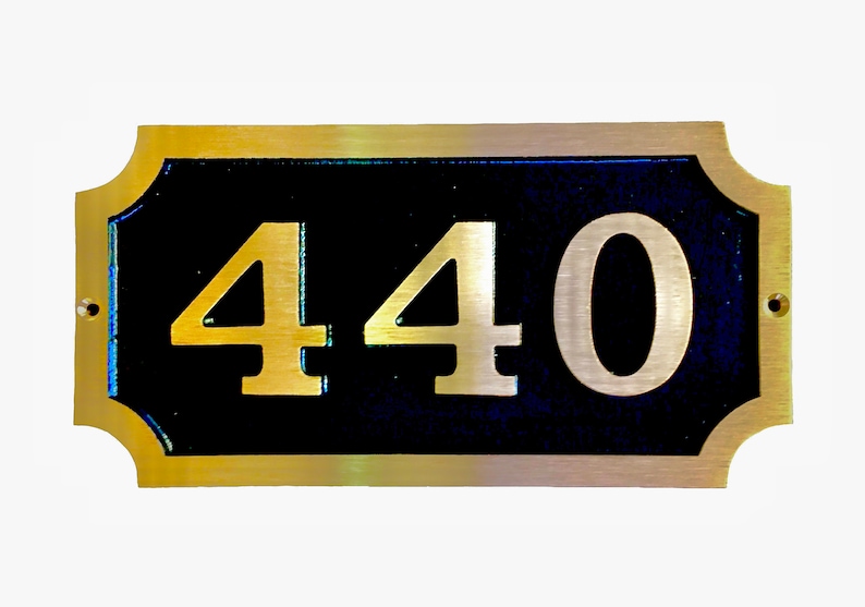 May include: A gold-coloured metal plaque with a black background and the number 440 in gold lettering.