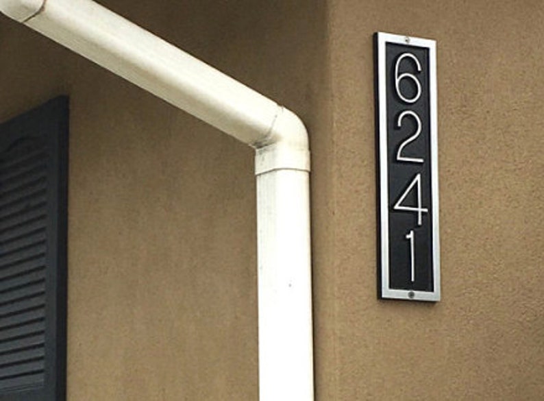 May include: A black and silver house number plaque with the numbers 6241.