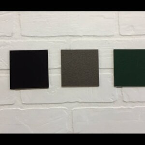 May include: Five color swatches on a white brick wall. The swatches are burgundy, black, gray, green, and brown.