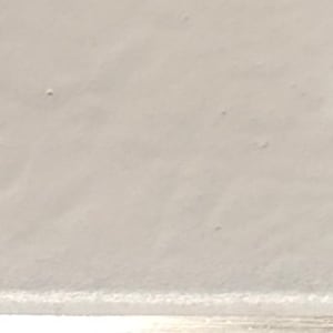 May include: A close-up of a white, smooth surface with a subtle texture. The surface appears to be made of a soft material, possibly fabric or paper.