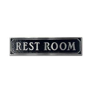Pu&ograve; includere: Cartello in metallo nero con scritta argentata "REST ROOM".