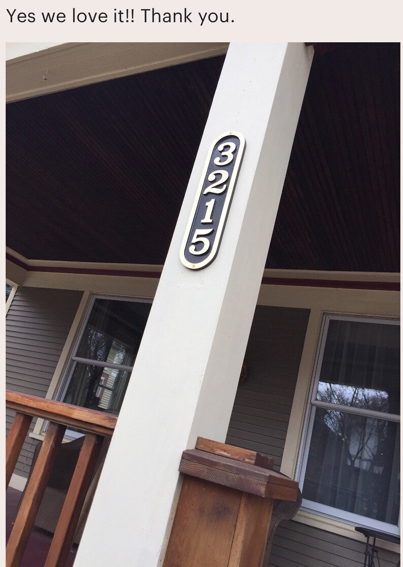 May include: A white wooden porch post with a black and gold house number plaque that reads "3215".