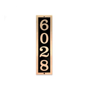 May include: Vertical house number sign with a black background and gold numbers. The numbers are 6028.