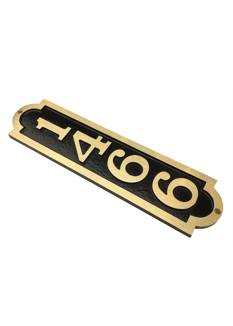 May include: A gold-colored metal house number sign with black background. The number 6041 is displayed in a vertical orientation.