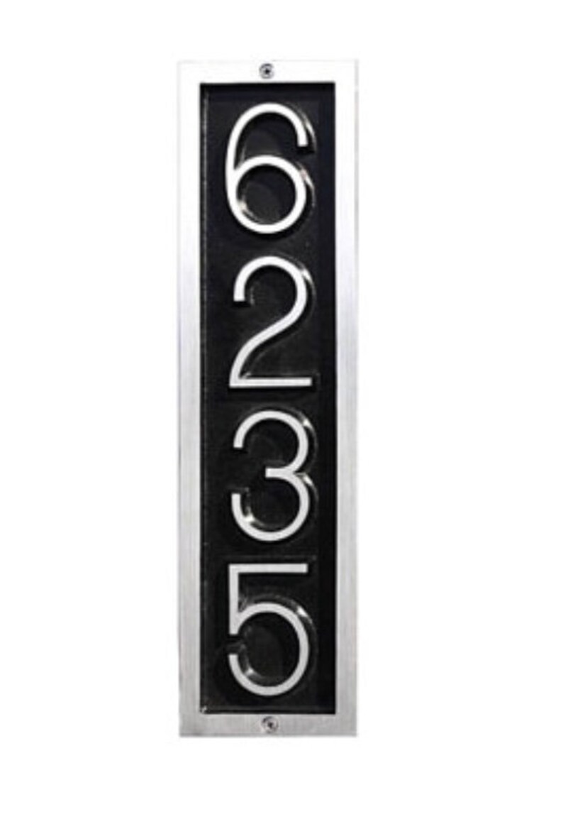 May include: A vertical silver-framed house number plaque with black background and white numbers 6235.