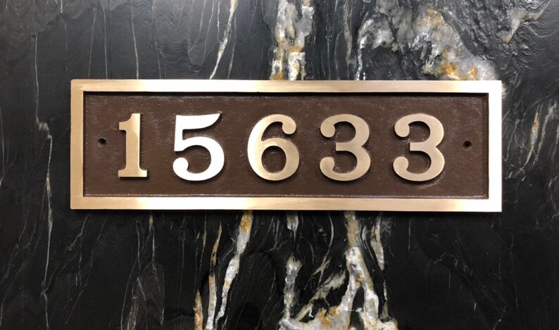 May include: A rectangular bronze plaque with a silver border and the number 15633 in silver lettering.