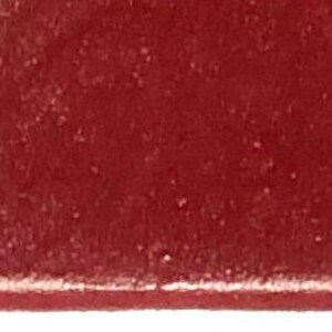 以下が含まれることがあります： 濃い赤色の口紅の弾丸のクローズアップ。口紅はマットな仕上がりです。