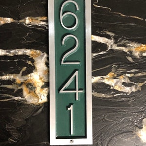 May include: A vertical silver and green house number plaque with the numbers 6241.