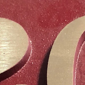 May include: Close-up of a house number plaque with the number "20" in raised, gold lettering on a burgundy background.