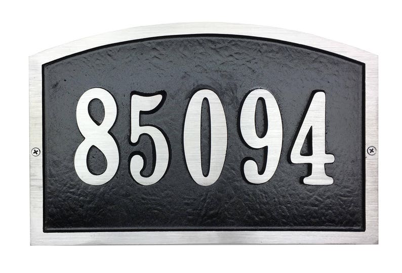 May include: Silver house number plaque with a black background and the number 85094 in large, white, stylised font.