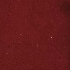 May include: A close-up of a deep red, smooth, solid surface.