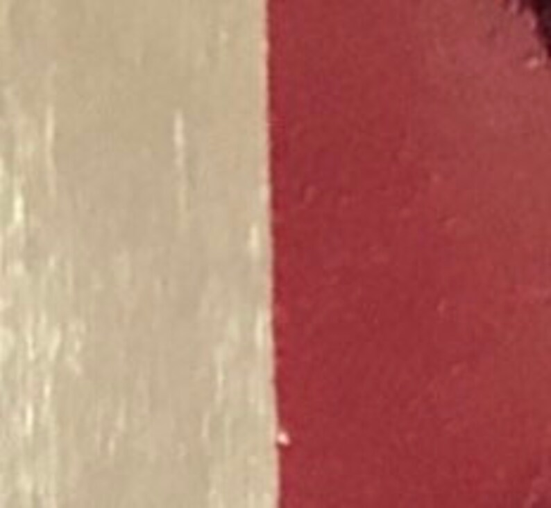 May include: A close-up of a beige and burgundy fabric with a subtle texture. The fabric is smooth and soft, with a slight sheen.