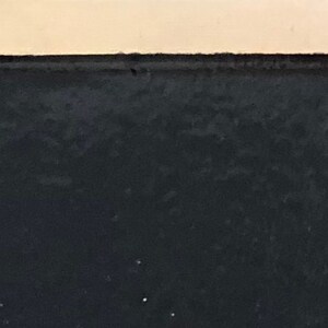 May include: A close-up of a black surface with a slightly textured finish.