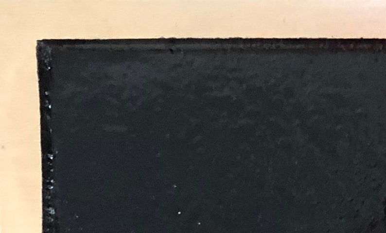 May include: A close-up of a black surface with a slightly textured finish.