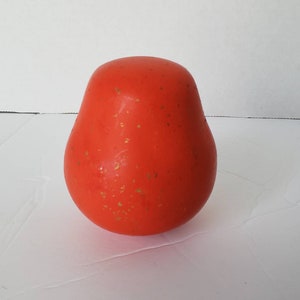 May include: A bright orange pear-shaped object with gold flecks on the surface.