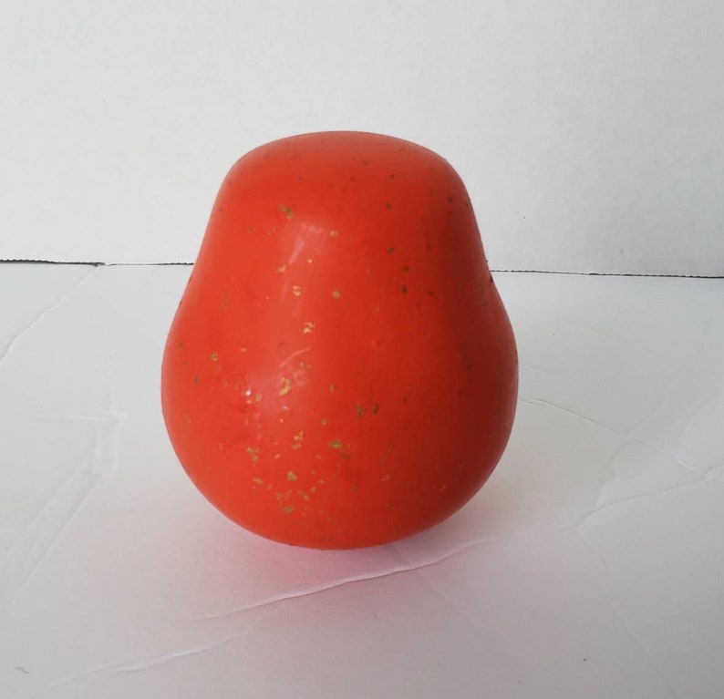 May include: A bright orange pear-shaped object with gold flecks on the surface.