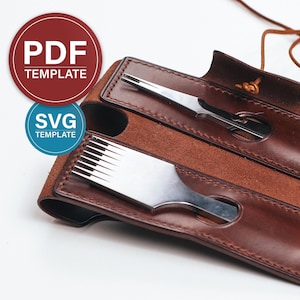 Könnte beinhalten: Ein braunes Lederetui mit Klappenverschluss, das für zwei Lederbearbeitungswerkzeuge ausgelegt ist. Das Etui hat einen genähten Rand und ein braunes Wildlederfutter. Die Werkzeuge sind ein Stechbeitel und ein Stechmeißel.