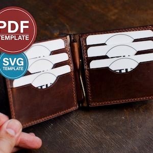 Op de afbeelding: Een bruine leren bifold portemonnee met meerdere kaartsleuven aan de binnenkant en een centrale metalen geldclip. De portemonnee is geopend en toont witte rechthoekige kaarten in de sleuven. Overliggende tekst PDF TEMPLATE en SVG TEMPLATE.