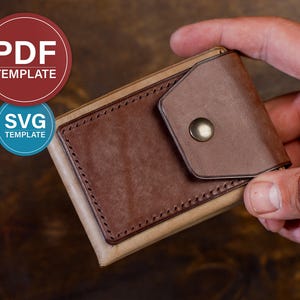 May include: A bi-fold leather wallet featuring a light tan base and a darker brown leather pocket with visible stitching. The pocket is secured by a metallic snap button. The image includes circular badges with the text PDF TEMPLATE and SVG TEMPLATE.