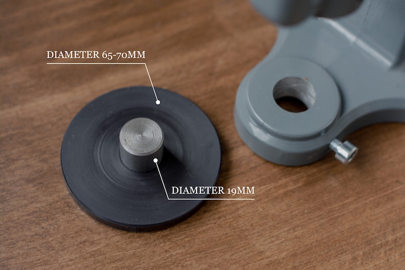 Puede incluir: Primer plano de una base de metal negro con un poste de metal plateado. La base tiene un di&aacute;metro de 65-70 mm y el poste tiene un di&aacute;metro de 19 mm.